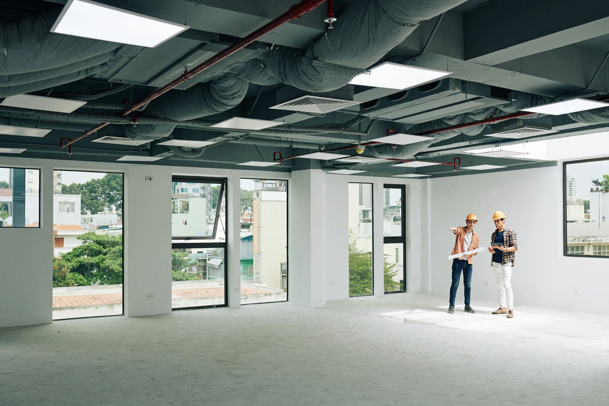 Professionals reviewing building plans in an unfinished interior